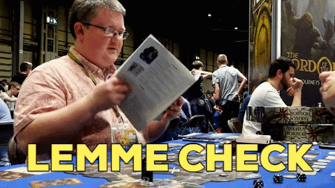 Man checking though the pages of a booklet whilst sitting at a table.